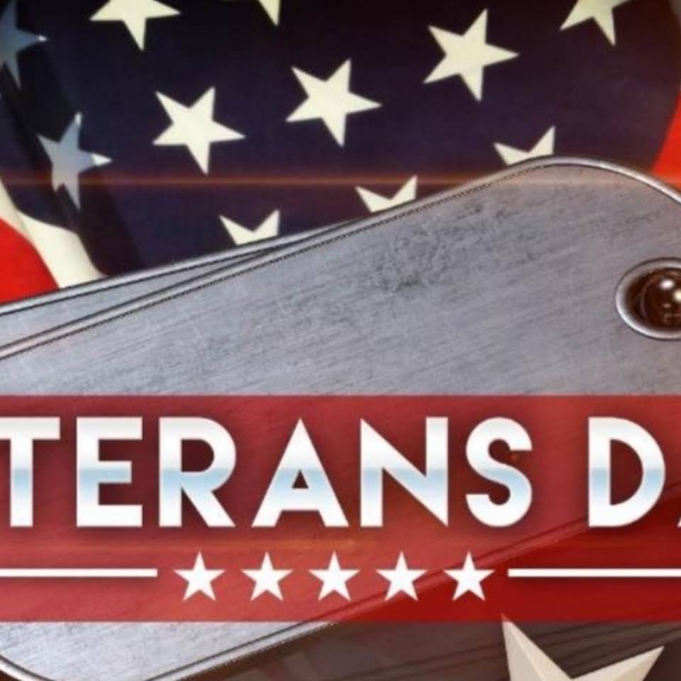 A veterans day sign with an american flag in the background