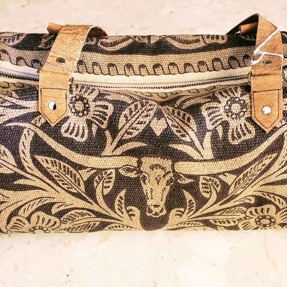 A brown and black bag with a cow design on it